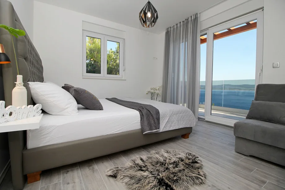 Dormitorio en la primera planta con cama doble y sofá cama, con salida al balcón