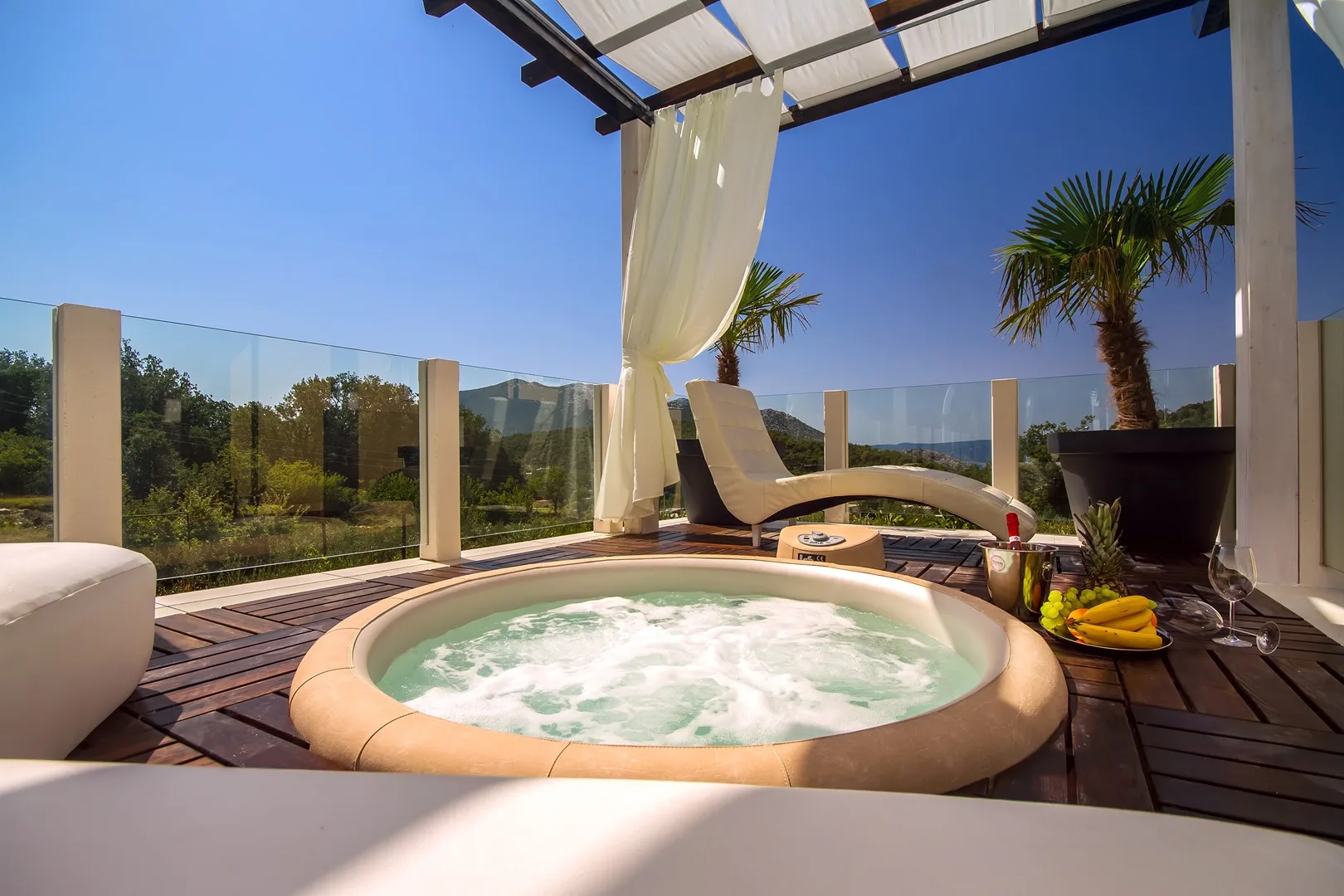 A rooftop terrace features a bubbling hot tub and lounge seating.