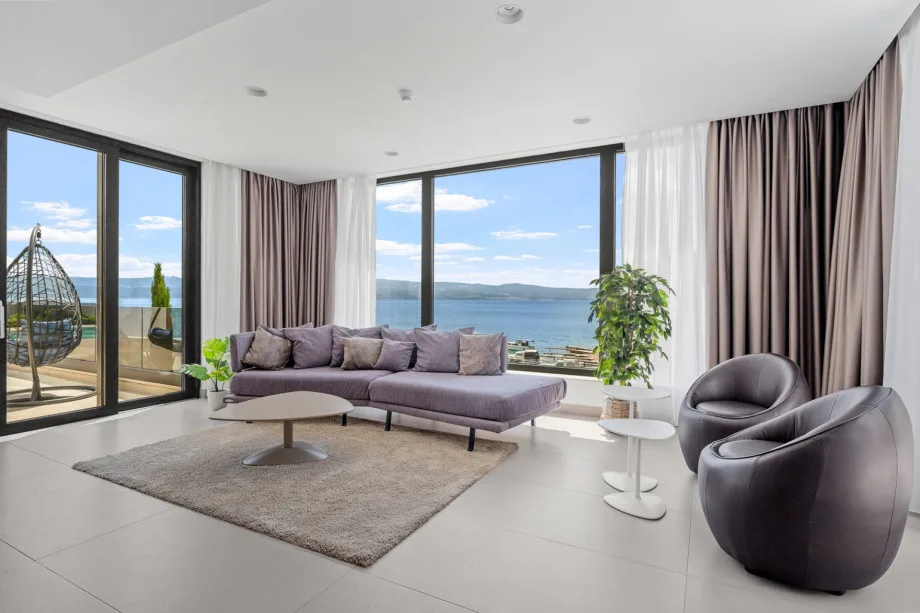 Living and dining area with sea views, fire place, TV, exit to outdoor dining