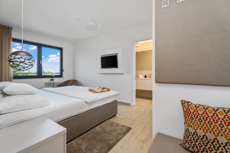 Uno de los 4 dormitorios con cama doble de 180 x 210 cm, baño privado, TV y sofá cama