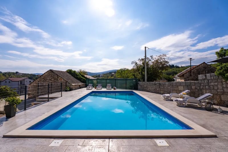 La amplia terraza para tomar el sol rodea la reluciente piscina privada de 50 m².