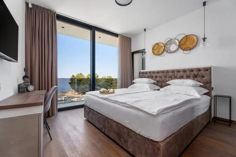 Bedroom 2 with a super king-size bed, en-suite bathroom, air conditioning and sea-view balcony
