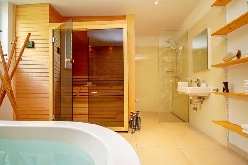 Zona de sauna con bañera y ducha independiente, en la planta baja