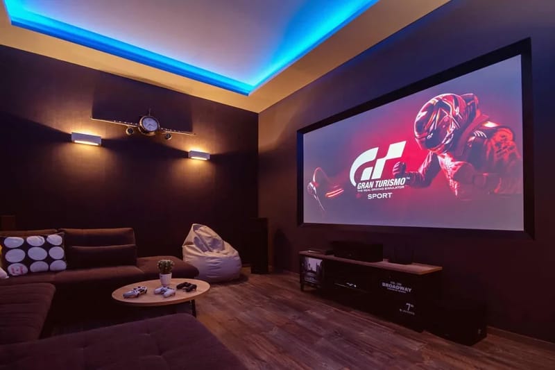 Sala de cine con un sofá enorme, pufs, aire acondicionado, wifi gratuito, PS4, Netflix y más