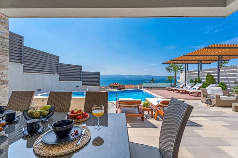 Zona de comedor exterior cubierta con vistas al mar