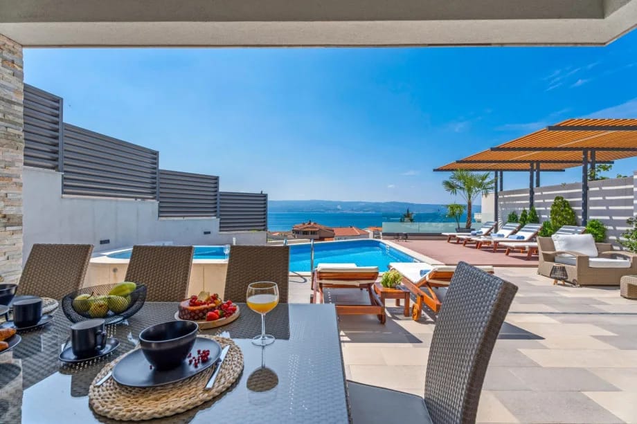 Zona de comedor exterior cubierta con vistas al mar