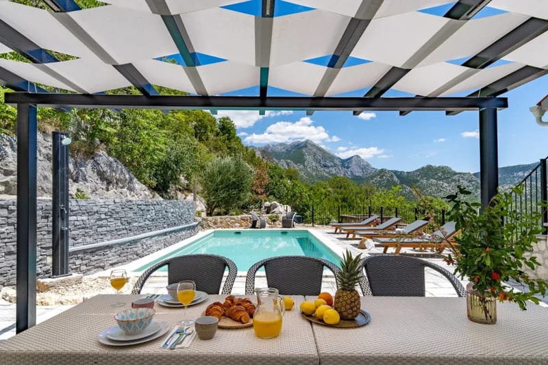 Zona de comedor al aire libre con barbacoa y sombrilla
