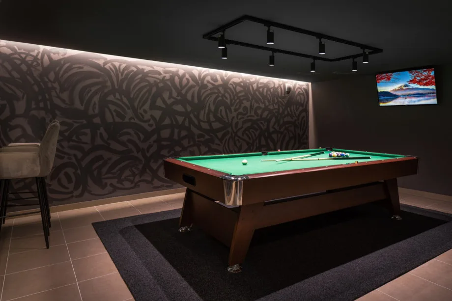 Sala de juegos con mesa de billar y TV