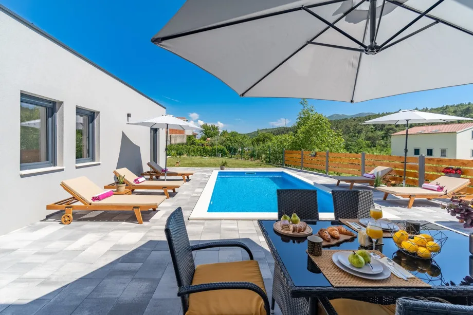 Private swimming pool with 6 deck chairs and outdoor dining area