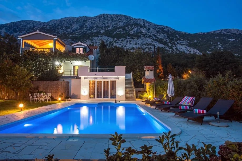 Vista nocturna de la villa y de la zona exterior.