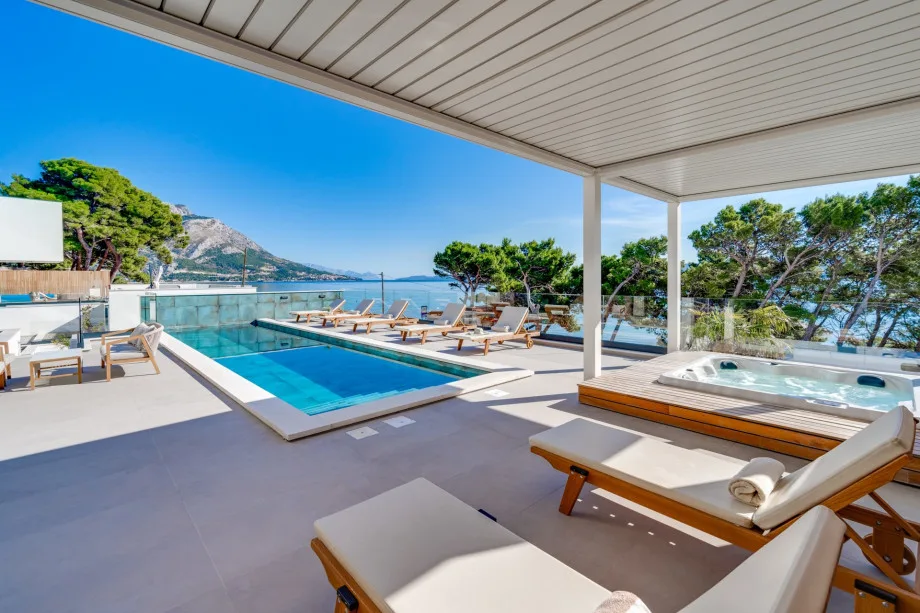 La zona exterior ofrece una piscina privada climatizada de 33 m², jacuzzi e increíbles vistas al mar