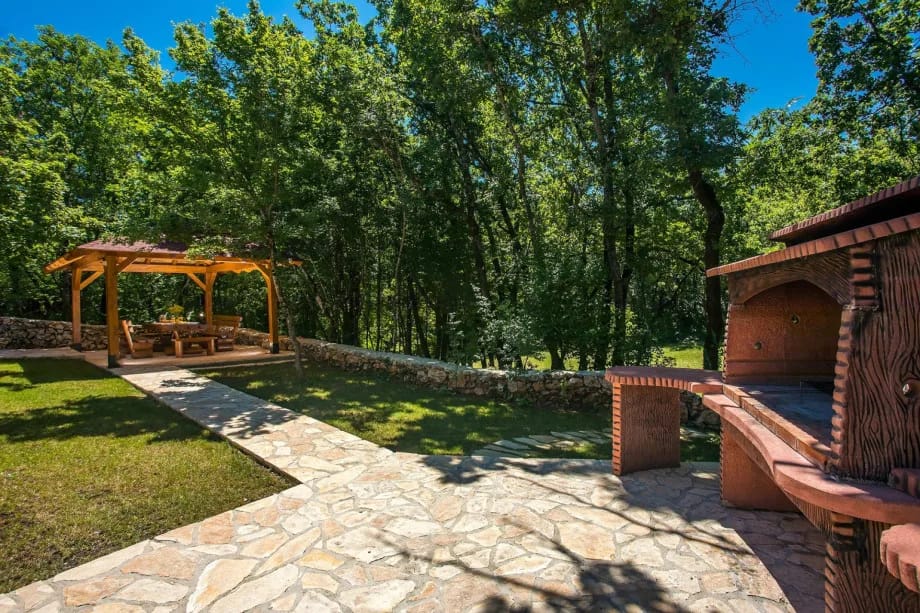 Zona exterior para comer para 12 personas a la sombra, con barbacoa tradicional