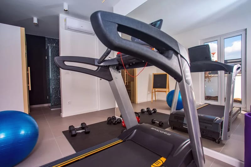 Equipamiento de gimnasio junto a la sauna con ducha