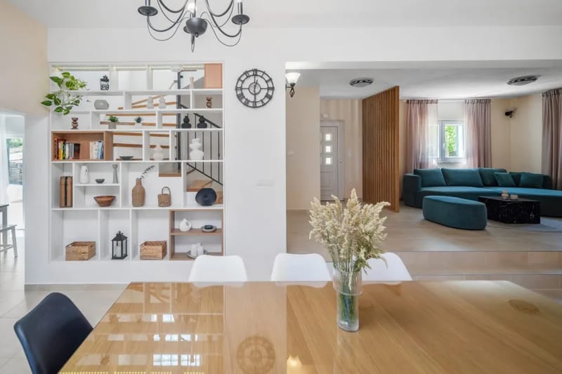 La planta baja cuenta con una sala de estar con aire acondicionado, equipada con un sofá y un televisor.