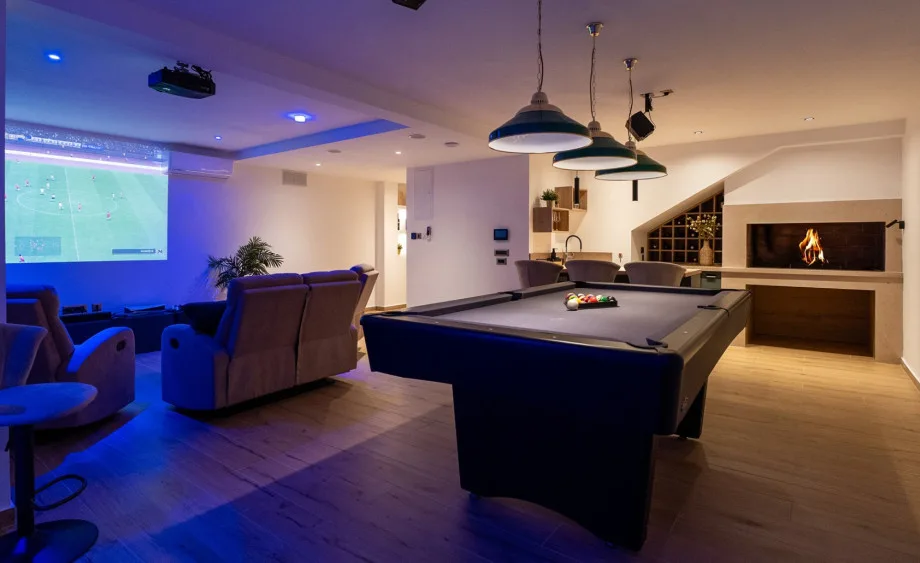 Un salón adicional acondicionado como zona de entretenimiento con una zona de barbacoa interior