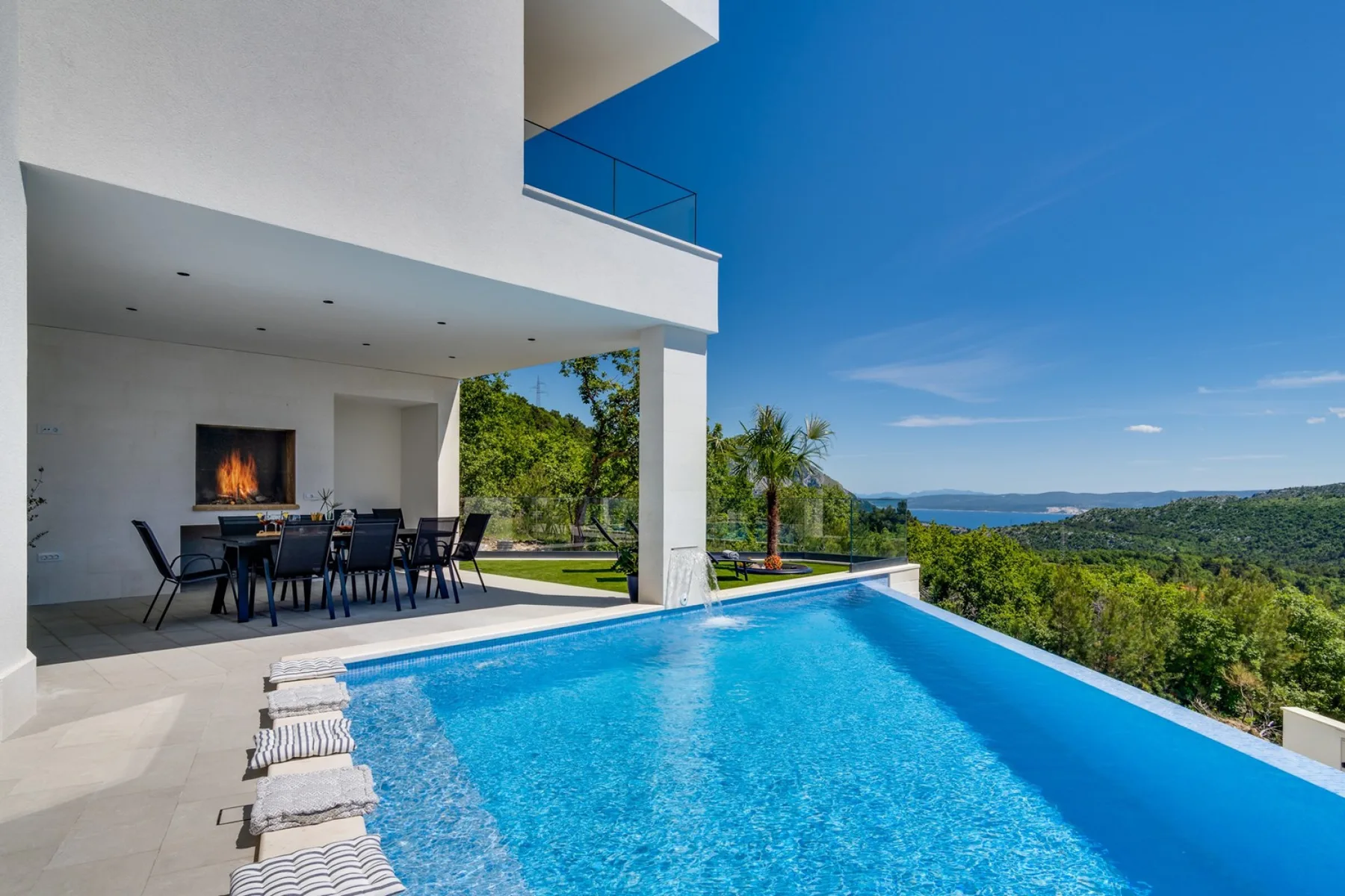 A swimming pool beside a covered outdoor dining area.
