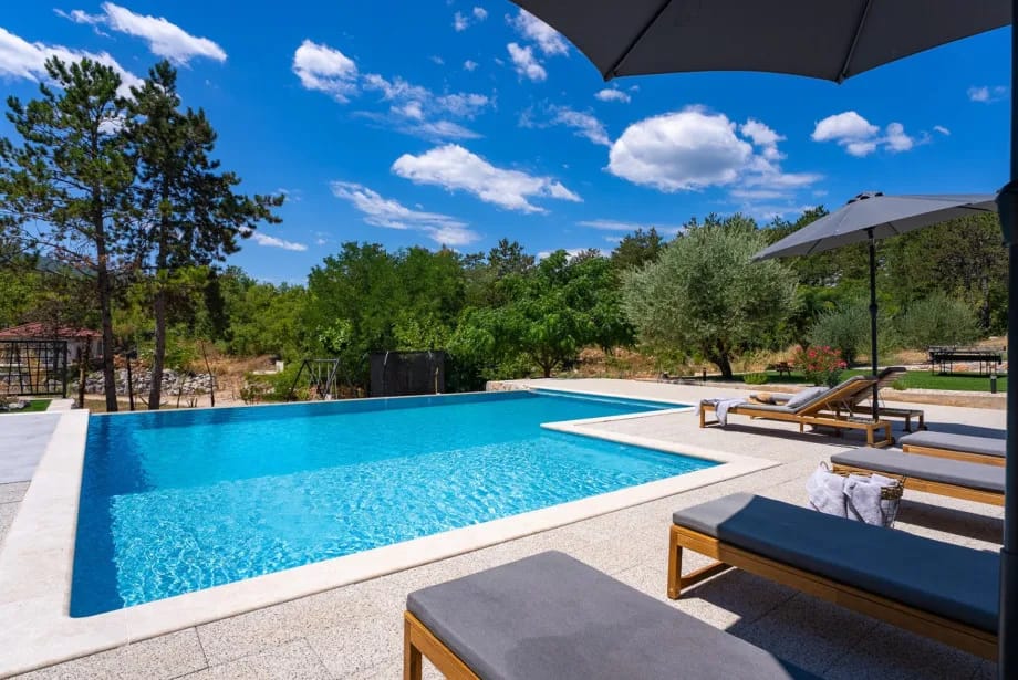 Sun deck with loungers and umbrellas around the infinity pool.
