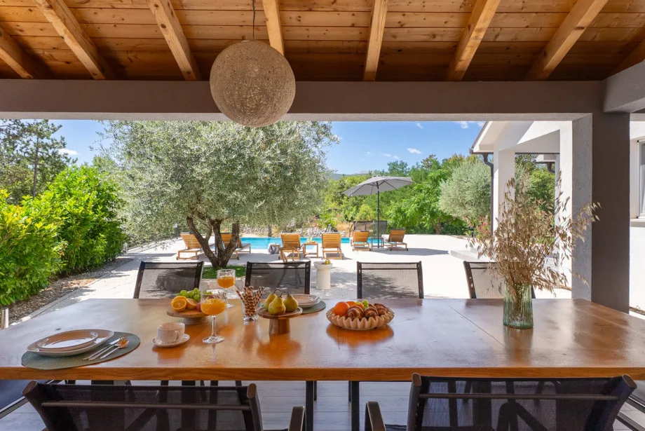La cocina de verano equipada con mesa de comedor al aire libre.