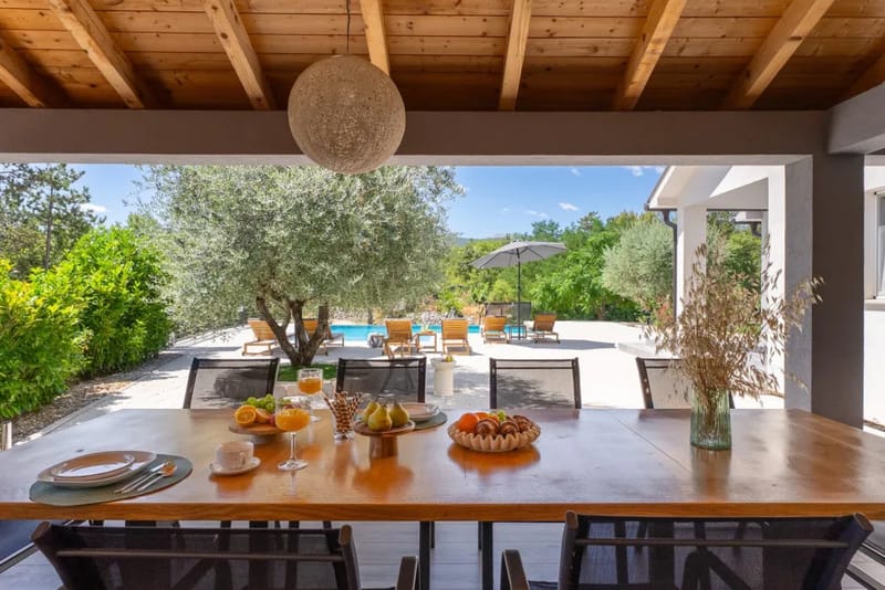 The equipped summer kitchen with outdoor dining table.