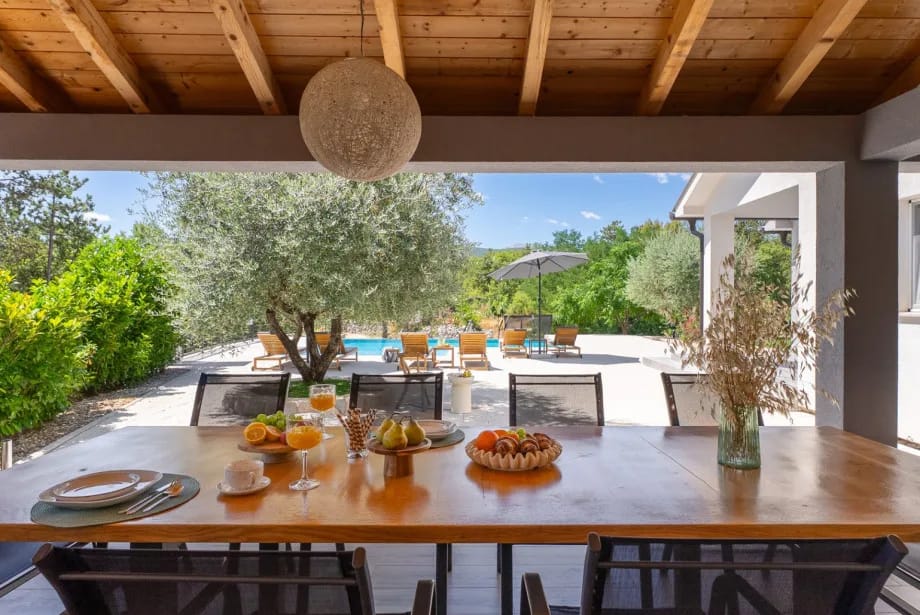 The equipped summer kitchen with outdoor dining table.