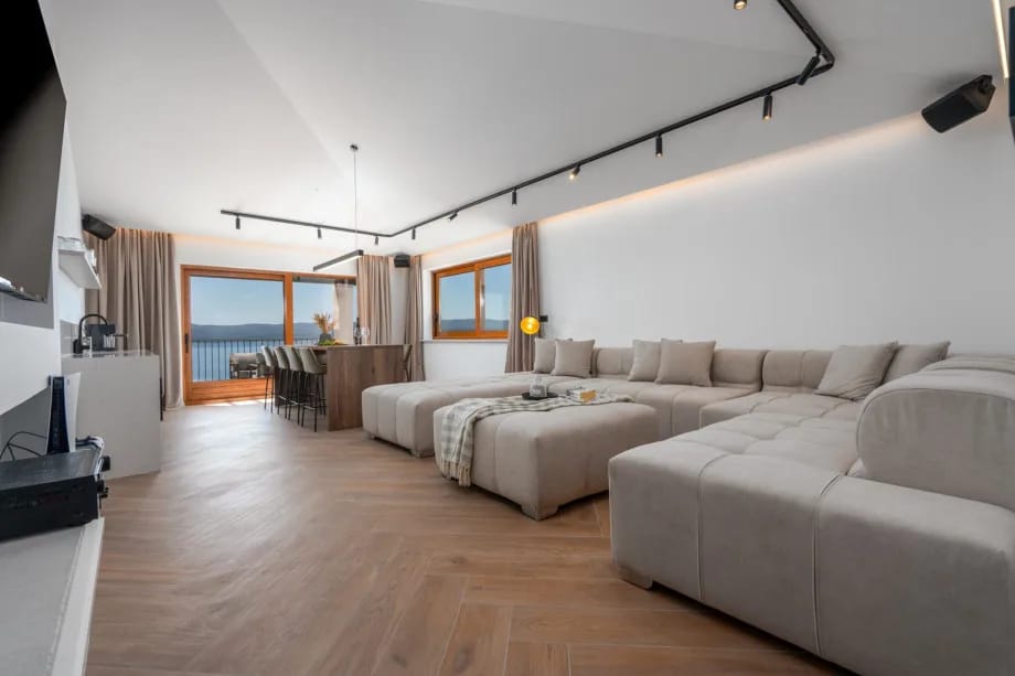 Sala multimedia con un sofá que se convierte en sofá cama para dos personas y un televisor de pantalla plana