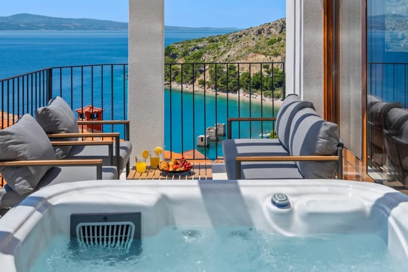 Terraza con bañera de hidromasaje, tumbonas, zona de estar y vistas panorámicas al mar y a las islas