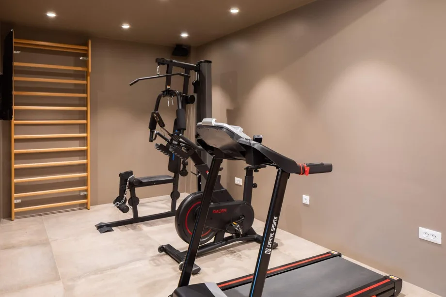 Gimnasio con máquina de ejercicios multifunción, cinta de correr y bicicleta estática