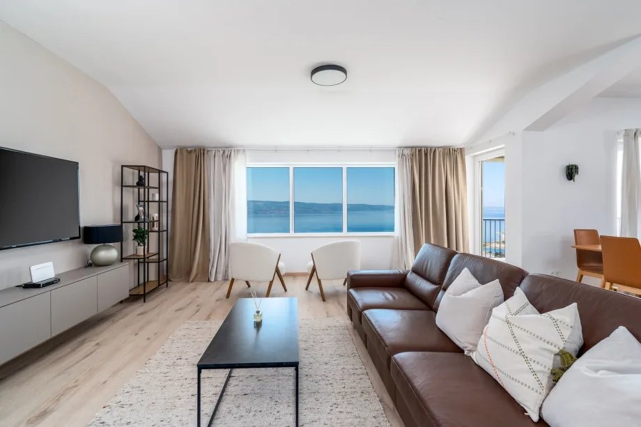 Living area with sofa, TV, air conditioning, kitchen and sea-view terrace