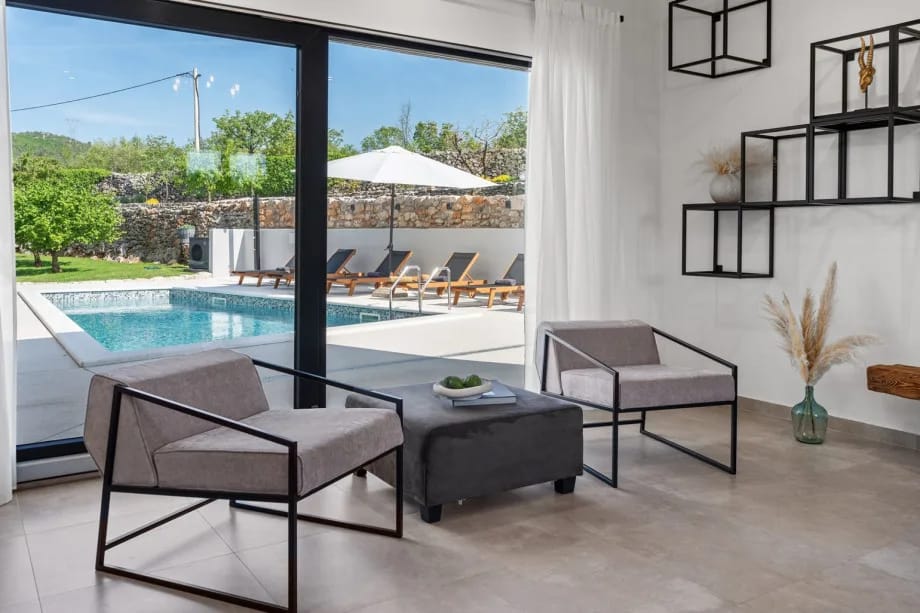 Zona de salón y comedor de planta abierta con vistas a la piscina