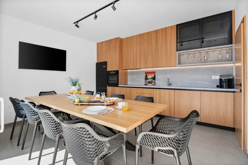 Fully equipped summer kitchen with a fridge, ice maker and dining table.