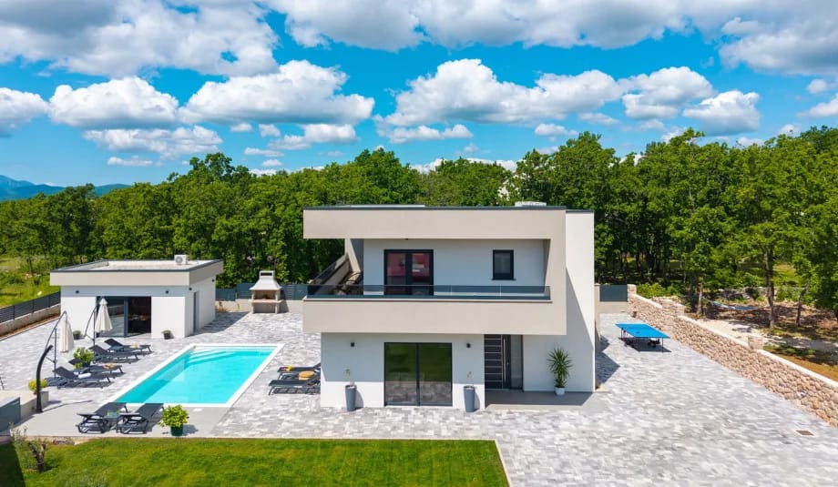 Piscina climatizada con una amplia zona para tomar el sol y ducha exterior.