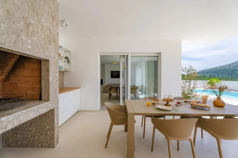 Zona de comedor exterior cubierta con cocina de verano