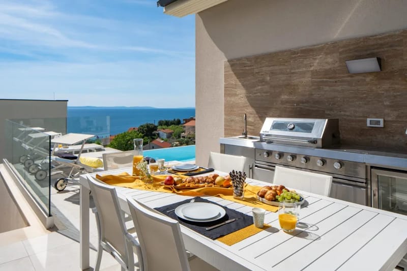 Zona de comedor exterior cubierta con barbacoa de gas