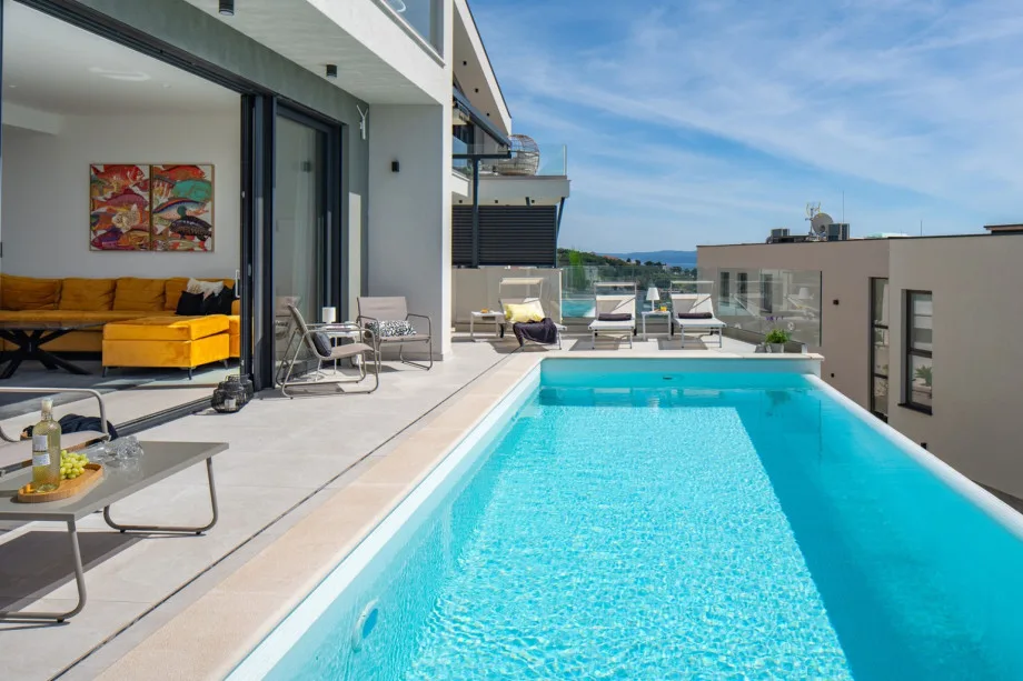 Floor-to-ceiling glass doors that blend the living area and pool area