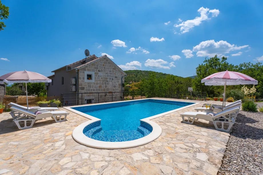 Una piscina privada de 52 m², 8 tumbonas con sombrillas