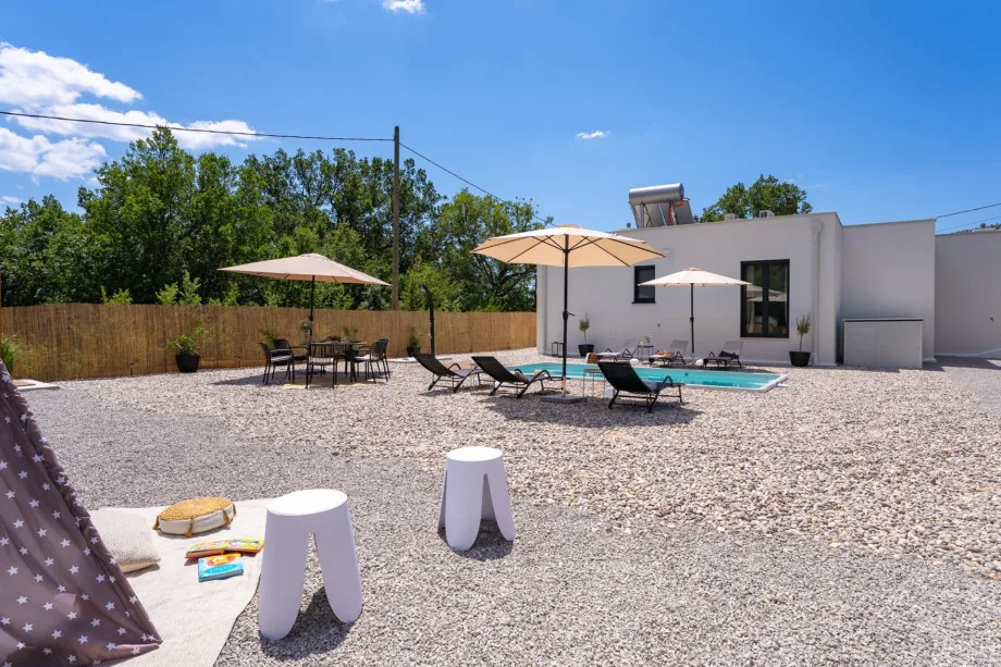 Piscina privada y terraza para tomar el sol cubierta de guijarros