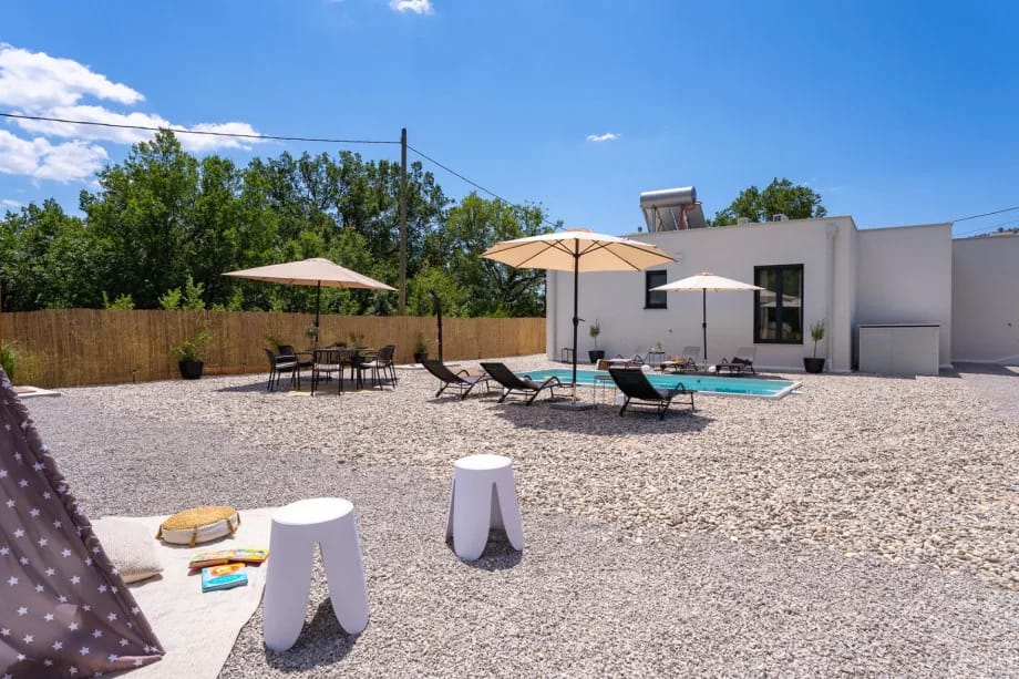 Piscina privada y terraza para tomar el sol cubierta de guijarros