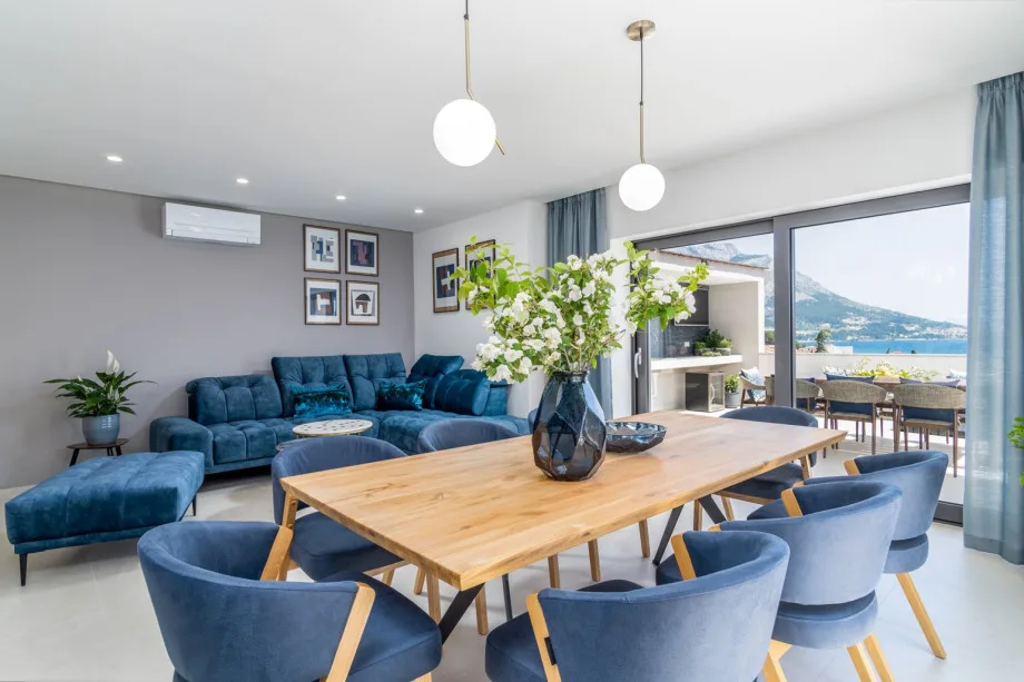 A living and dining area overlooking the pool and sea