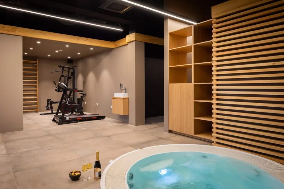 The wellness area includes a gym with multifunctional workout equipment, treadmill, and stationary bicycle.