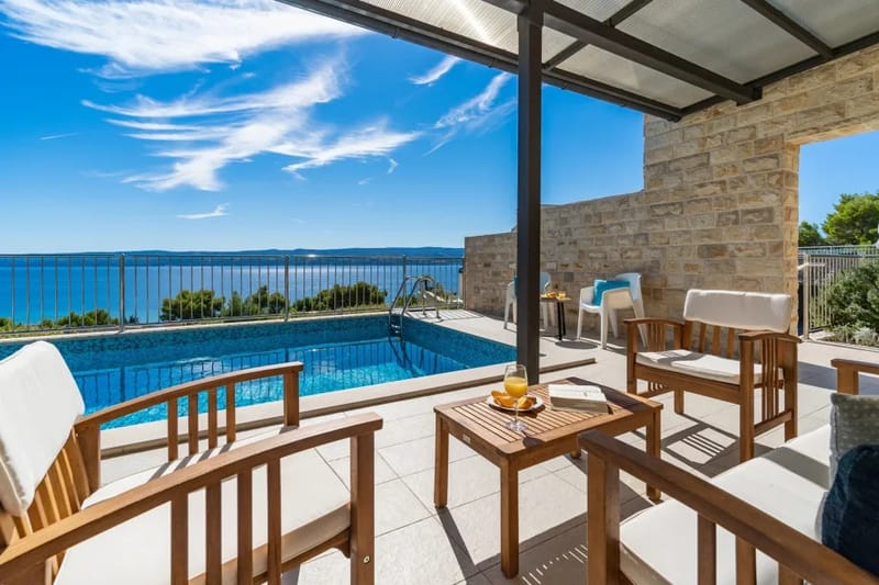 Outdoor sitting area next to the pool with sea view