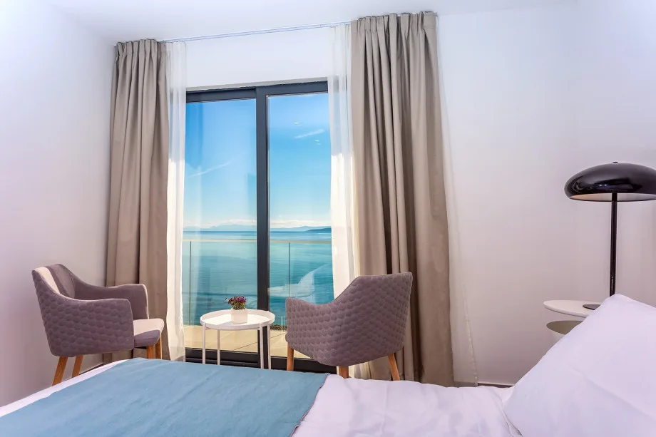 Master bedroom with king-size bed, television, air conditioning, and en-suite bathroom with bathtub.