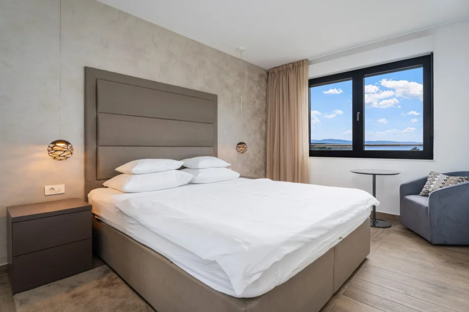 Bedroom with double bed, en-suite bathroom, TV and sea views