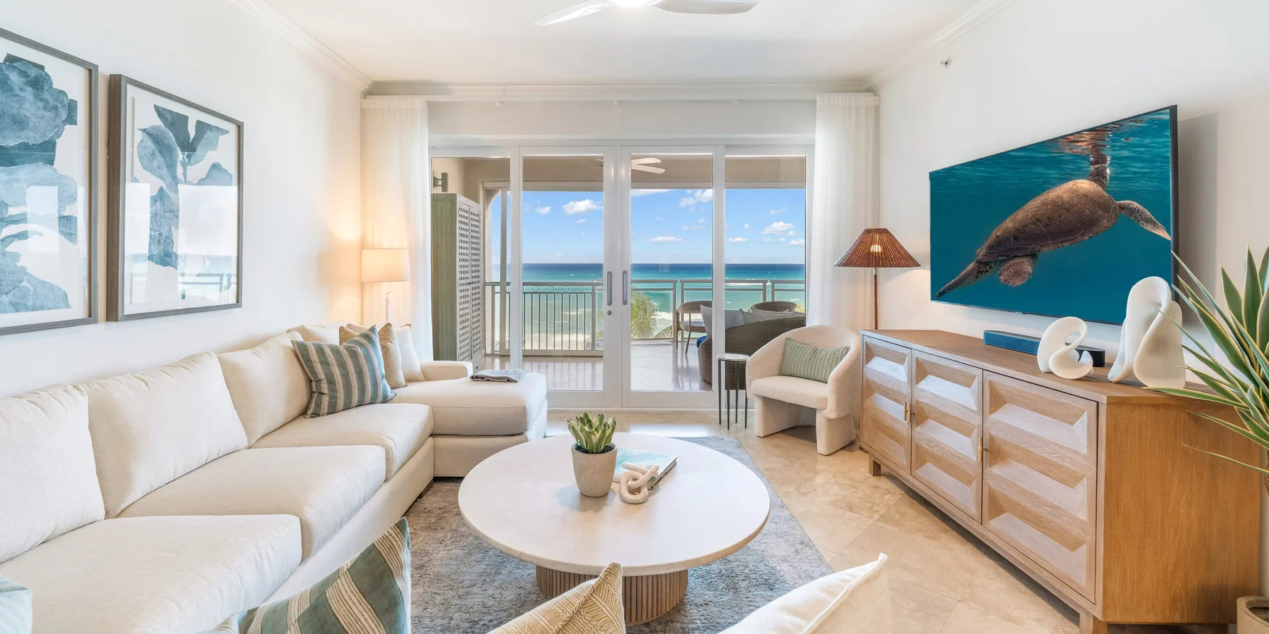 Una luminosa sala de estar se abre a un balcón con vistas al mar.