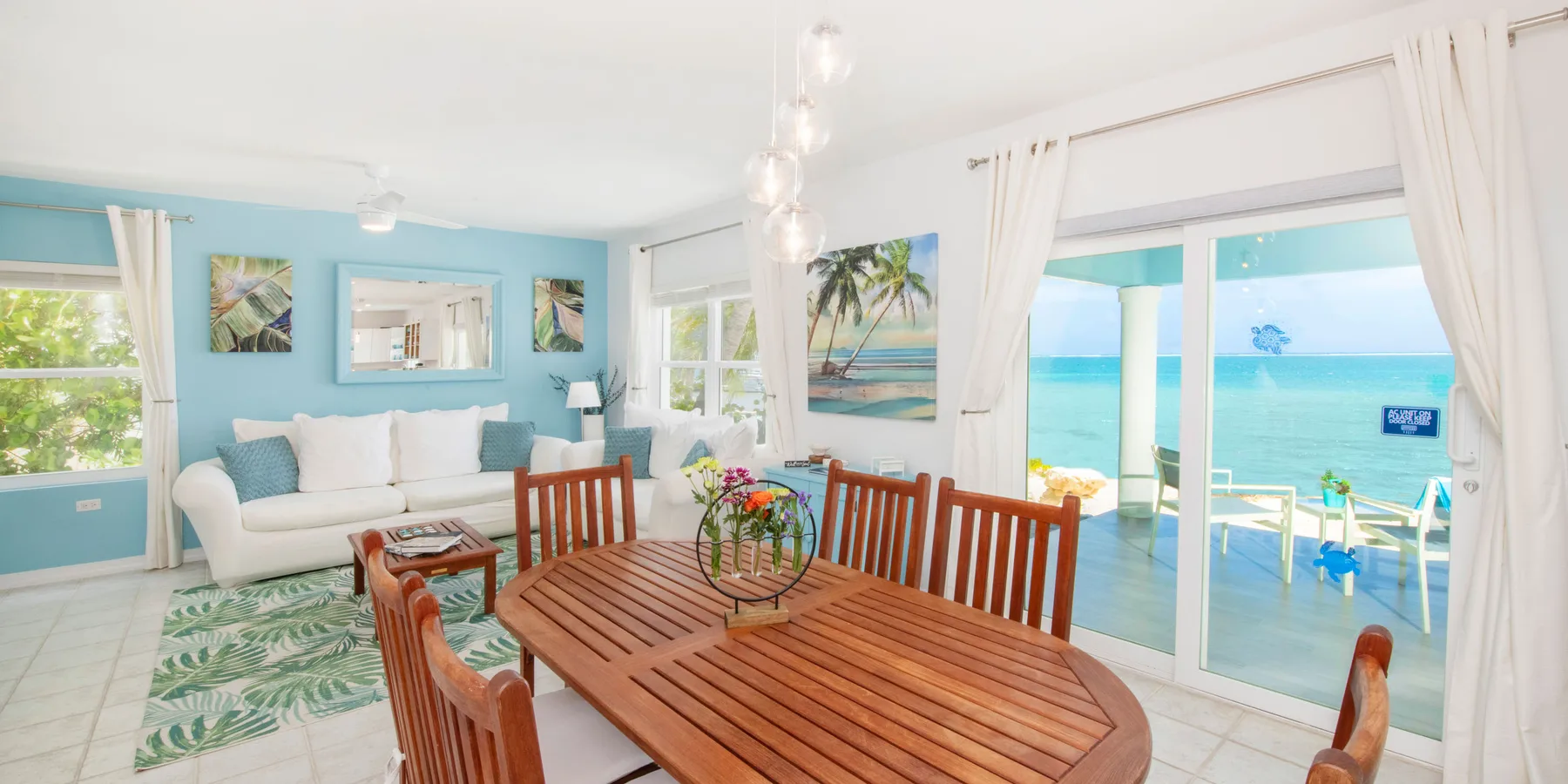 Una luminosa sala con comedor se abre a un patio con vista al mar.