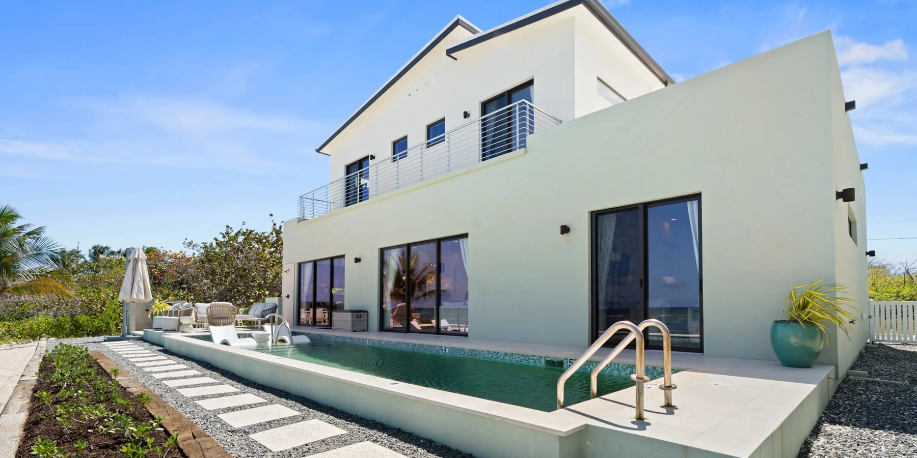 Una casa moderna da a una piscina y un jardín ajardinado.