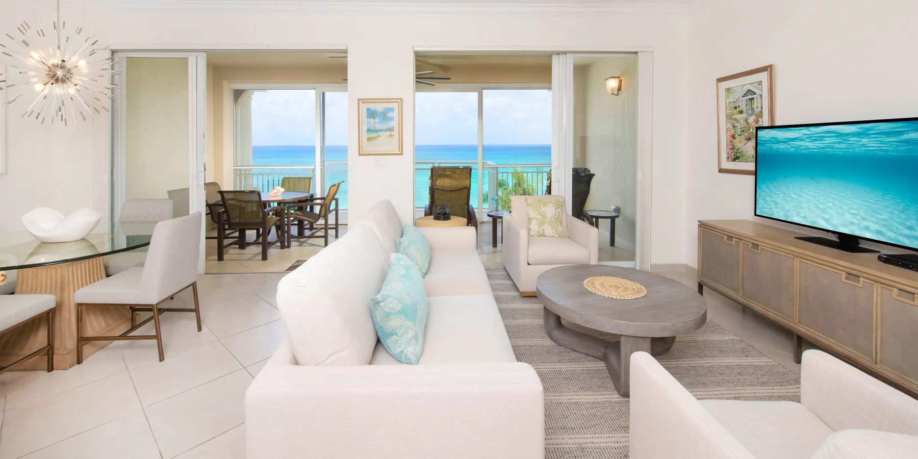 Una sala luminosa con asientos alrededor de una mesa baja y vistas al mar.