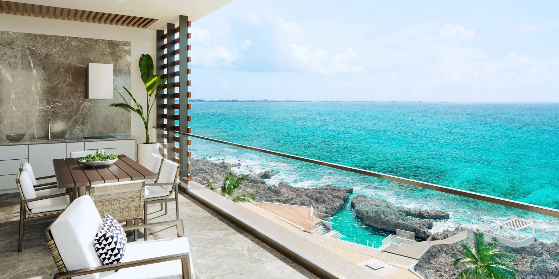 A seaside patio has a dining table and seating overlooking turquoise water.