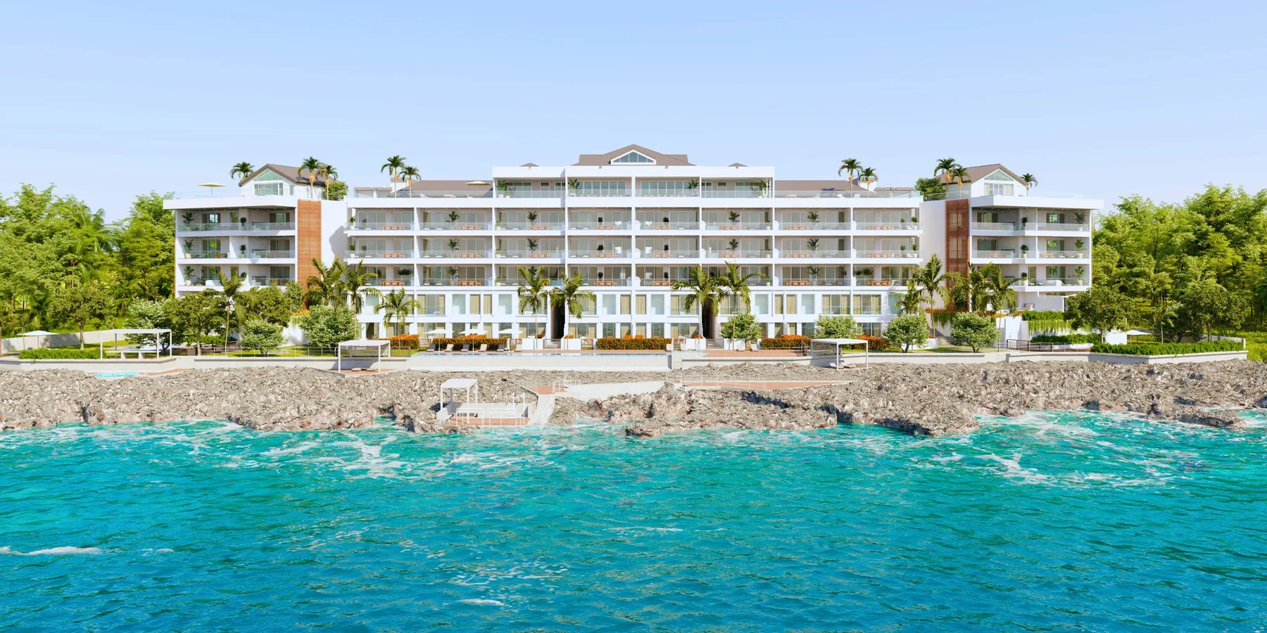 Un edificio turístico junto al agua turquesa y una costa rocosa.