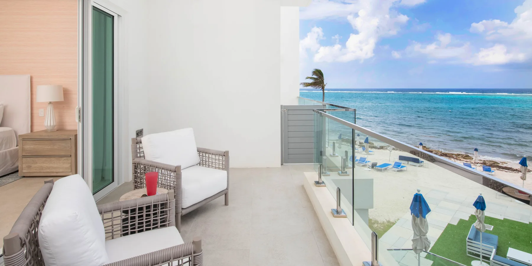 Un dormitorio da a un balcón con vistas a la playa y al océano.