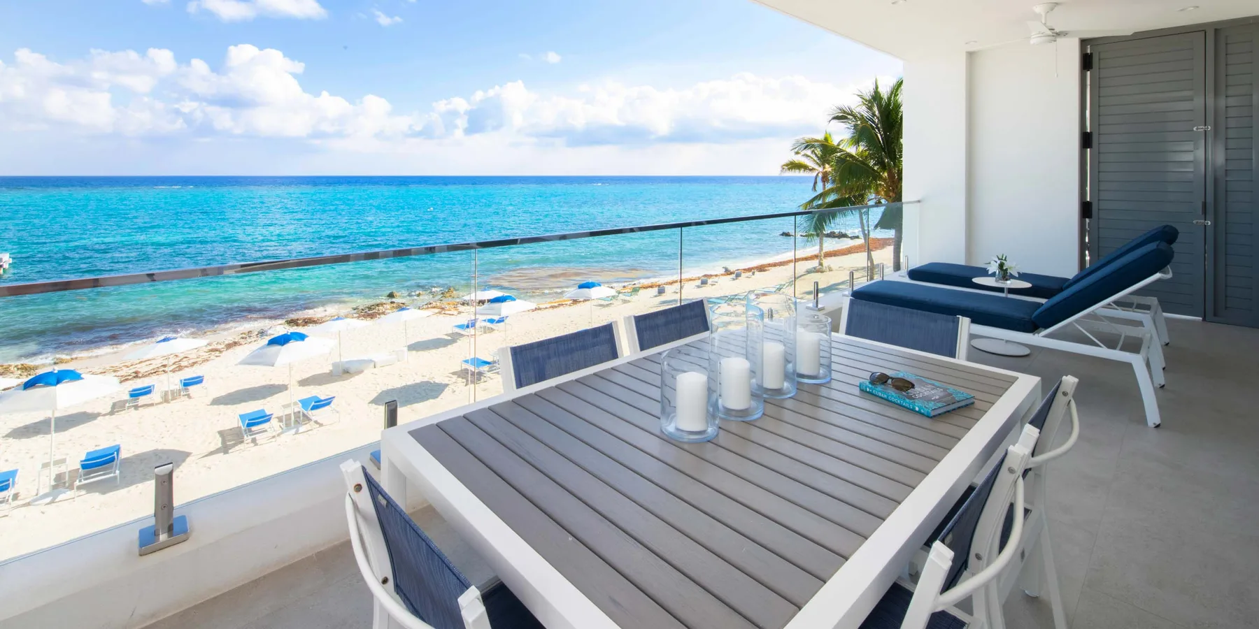 Una terraza frente a la playa con una mesa de comedor al aire libre y vistas al mar.